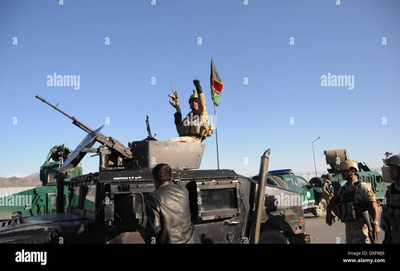 Kabul, Afghanistan. 25th Mar, 2014. An Afghan policeman keeps watch on a military vehicle at the site of an attack in Kabul, Afghanistan, March 25, 2014. A group of armed militants raided a sub-office of Afghan election commission in Darul Aman area in western Kabul Tuesday morning, leaving 10 people including five attackers dead. © Ahmad Massoud/Xinhua/Alamy Live News Stock Photo