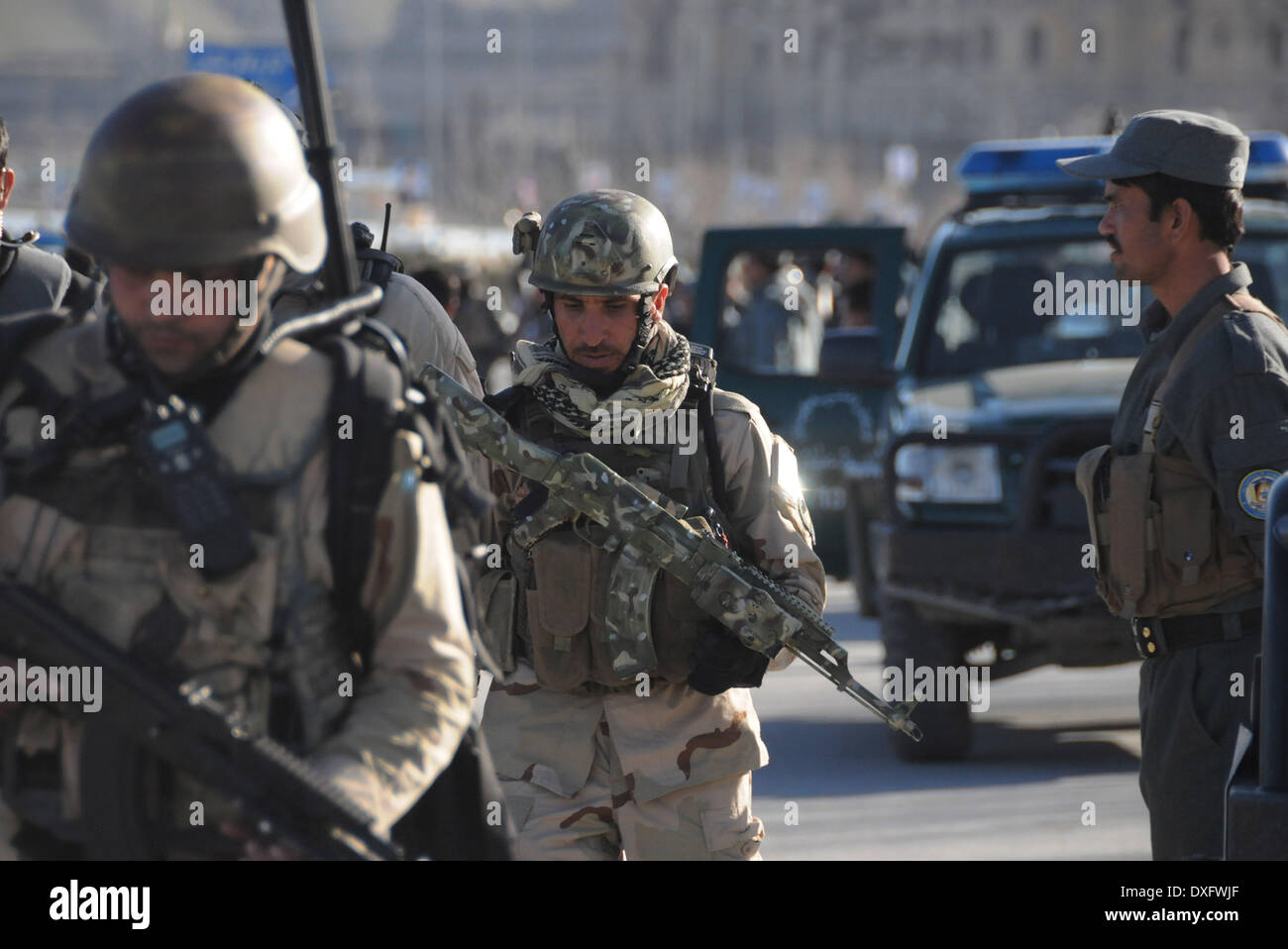 Kabul, Afghanistan. 25th Mar, 2014. Afghan policemen leave the site of an attack in Kabul, Afghanistan, March 25, 2014. A group of armed militants raided a sub-office of Afghan election commission in Darul Aman area in western Kabul Tuesday morning, leaving 10 people including five attackers dead. © Ahmad Massoud/Xinhua/Alamy Live News Stock Photo