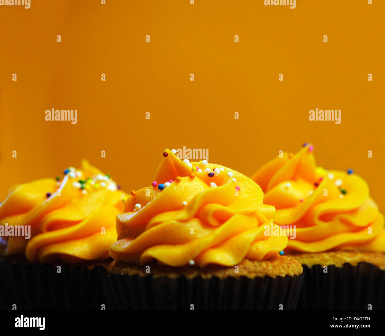 Trio Of Orange Iced Cupcakes In A Row Stock Photo