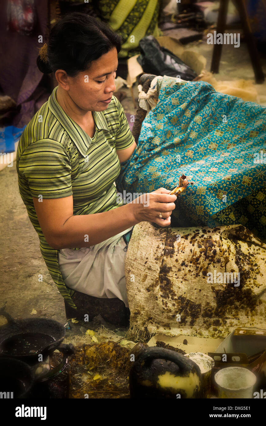 Indonesia, Java, Solo, Female artisanal worker applying hot wax patterns on cloth using a wax pen or so called canting Stock Photo