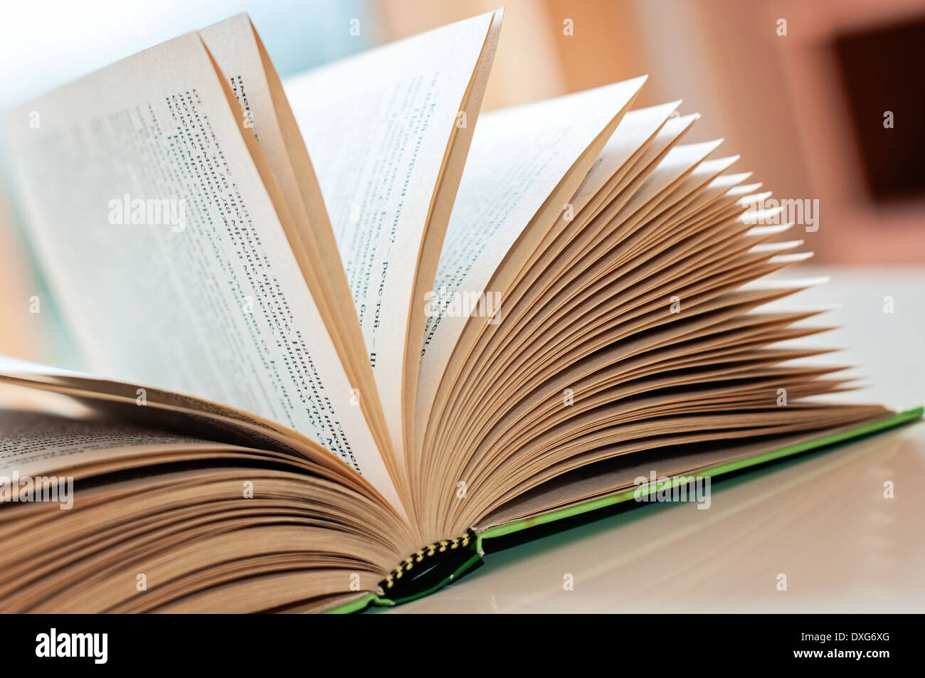 Open book on a white table in front a window Stock Photo