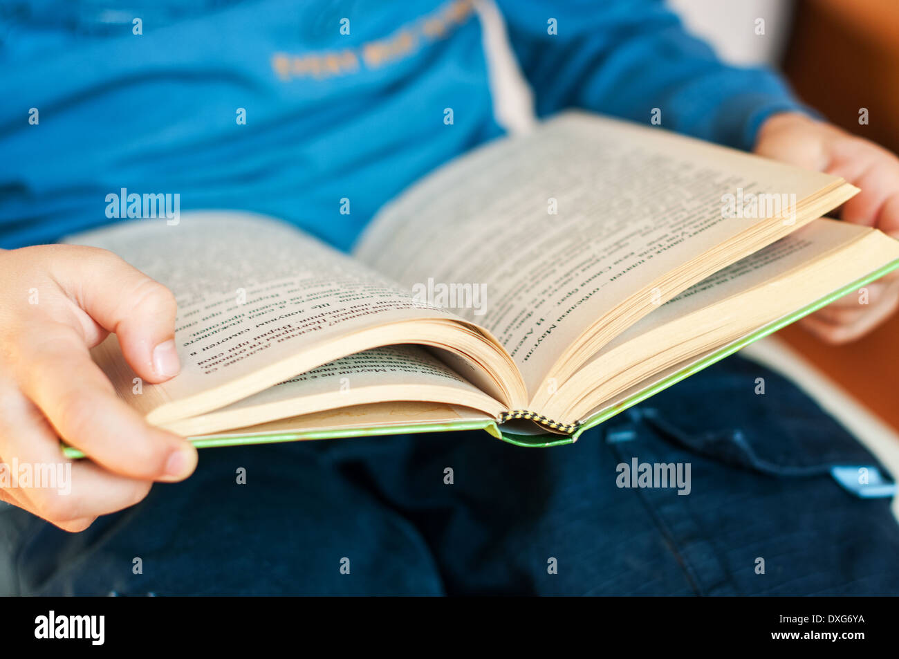Open book in child hands- selective focus on the front Stock Photo