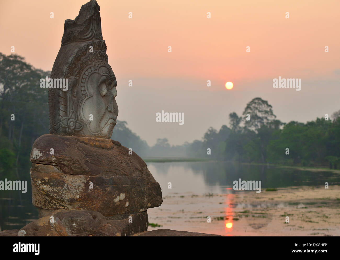 Sunrise over water  and in between row of gods on path to  Angkor Thom, South Gate,  Siem Reap, Cambodia, Southeast Asia Stock Photo