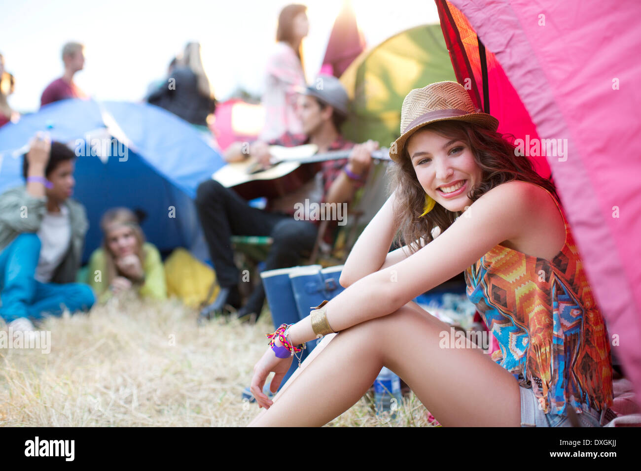 Portrait of woman sitting at front of tent at music festival Stock Photo