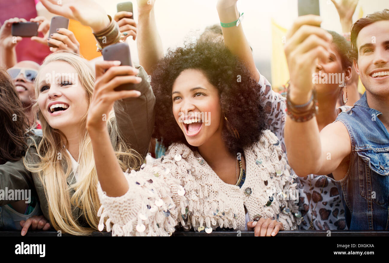 Fans with camera phones cheering at music festival Stock Photo