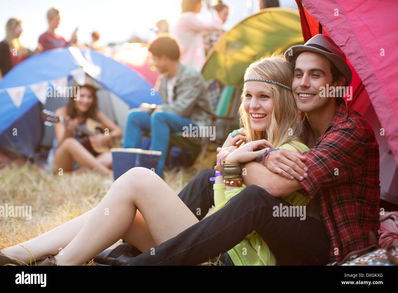 Couple hugging outside tent at music festival Stock Photo