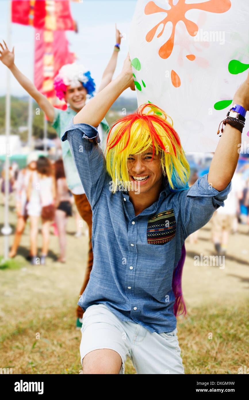 Playful men cheering in wigs at music festival Stock Photo