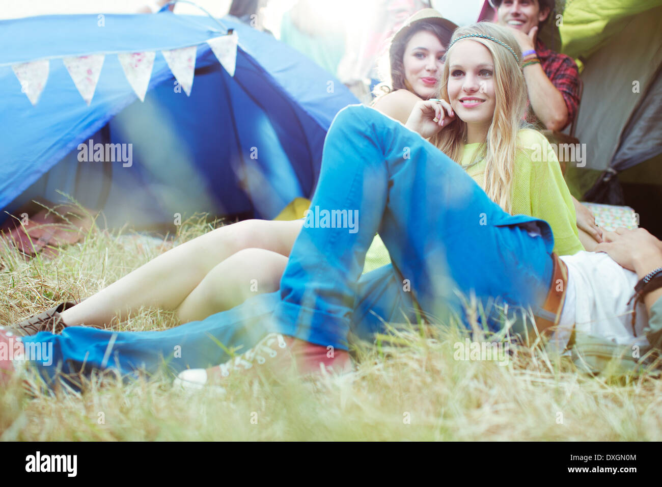 Friends relaxing outside tents at music festival Stock Photo