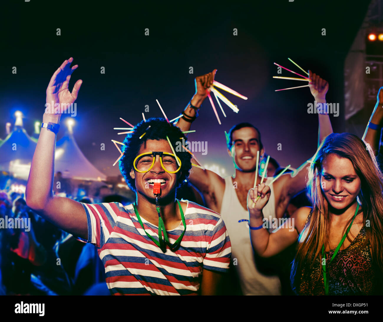 Fans with glow sticks cheering at music festival Stock Photo