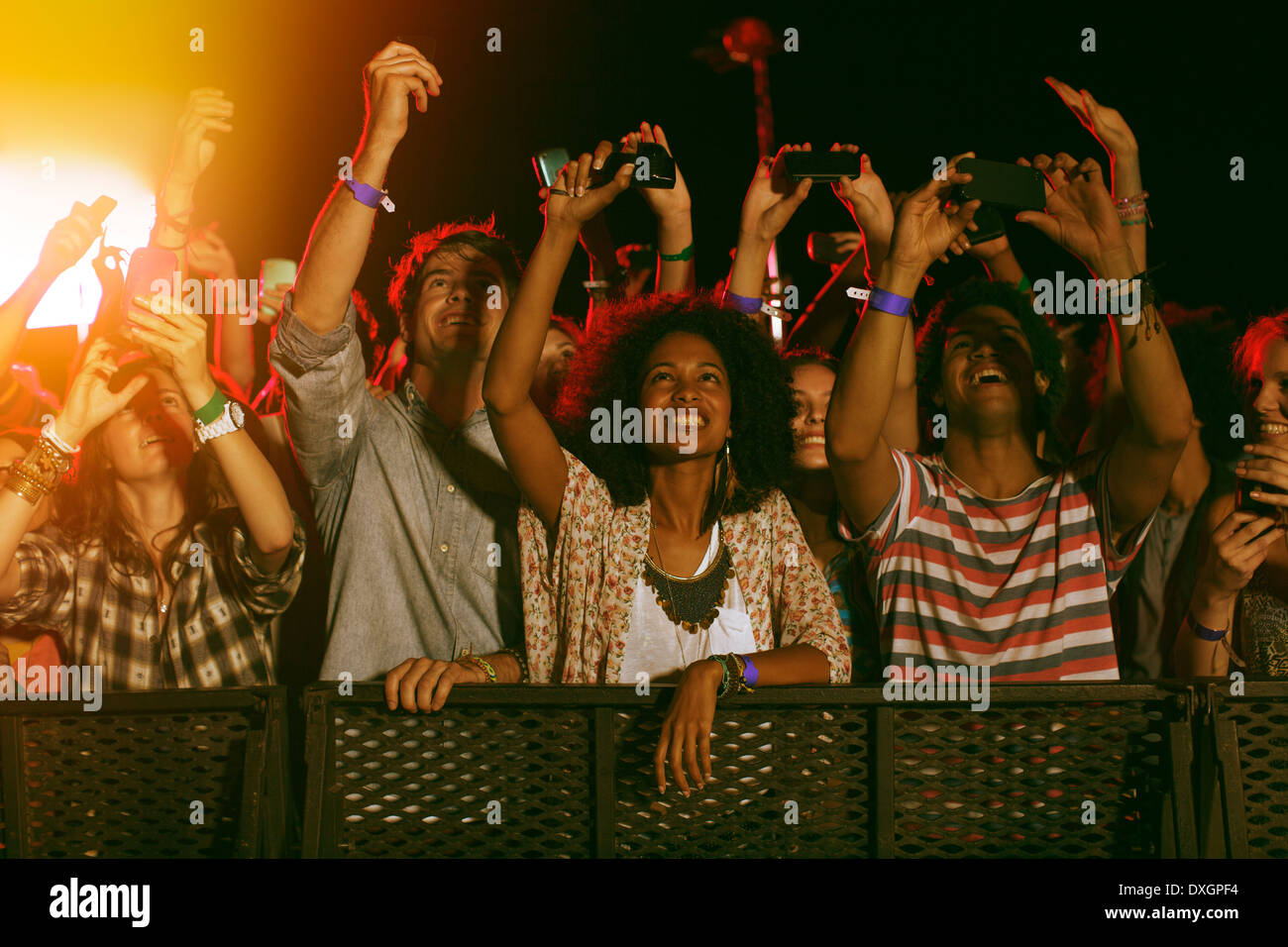Fans with camera phones cheering at music festival Stock Photo