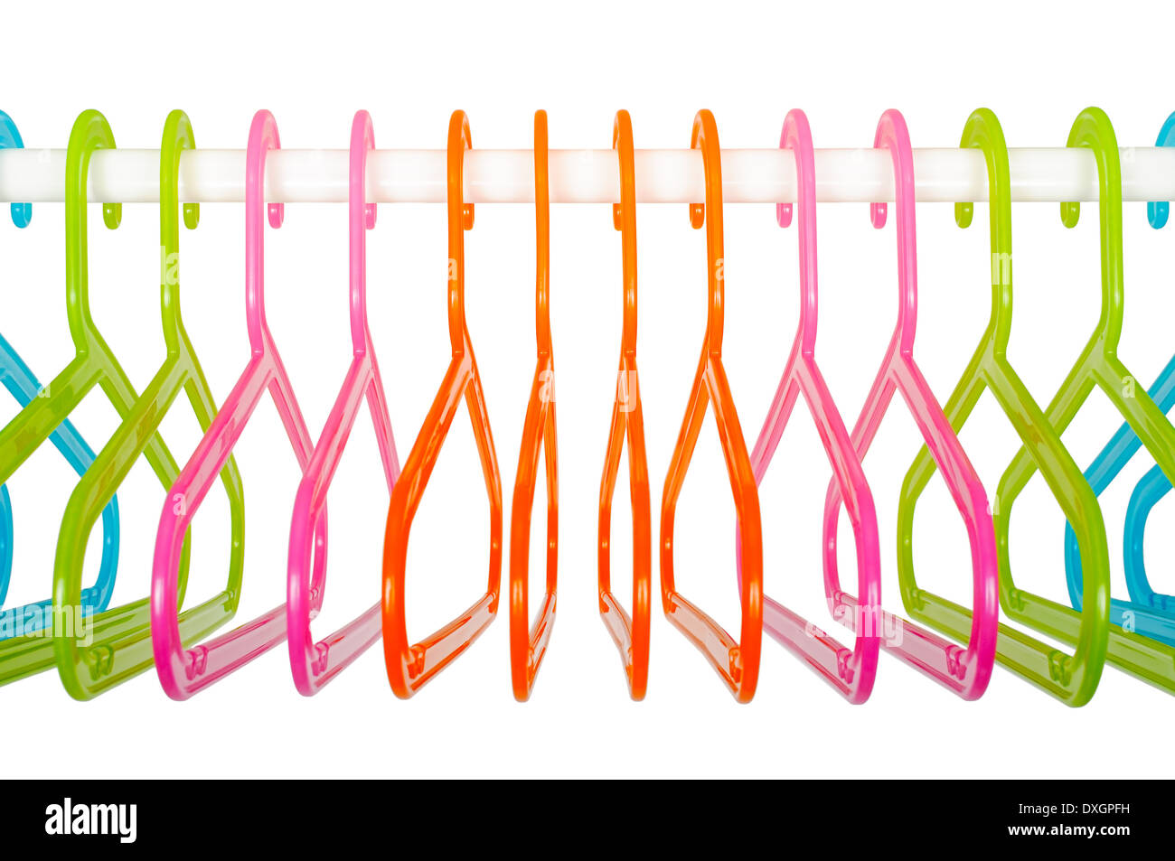 Colored plastic hangers hanging on a rod in an empty white closet Stock Photo