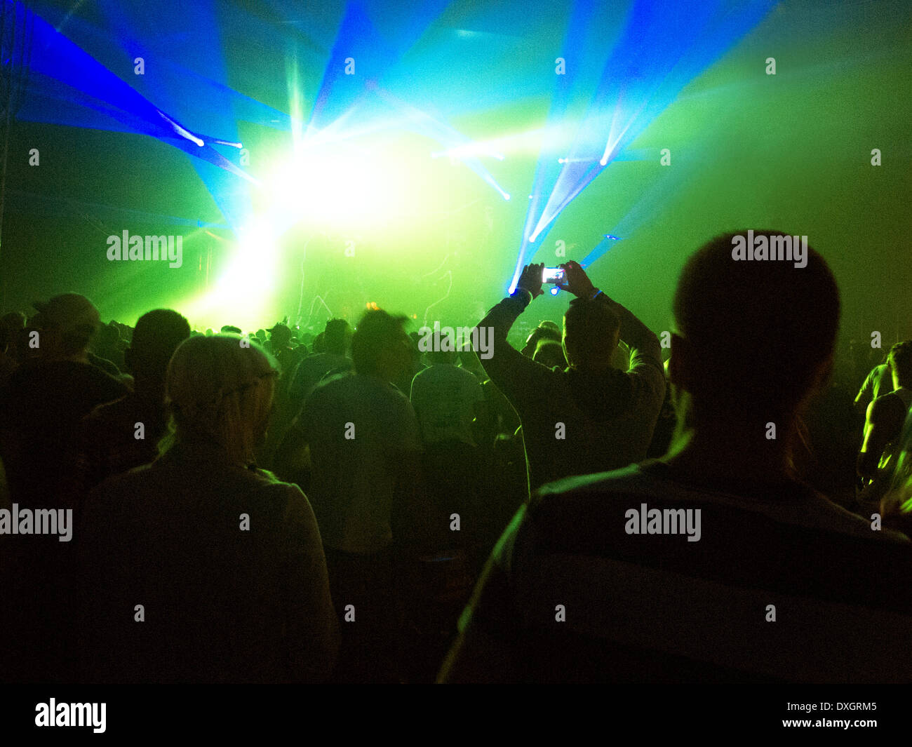 Silhouette of crowd facing illuminated stage at music festival Stock Photo