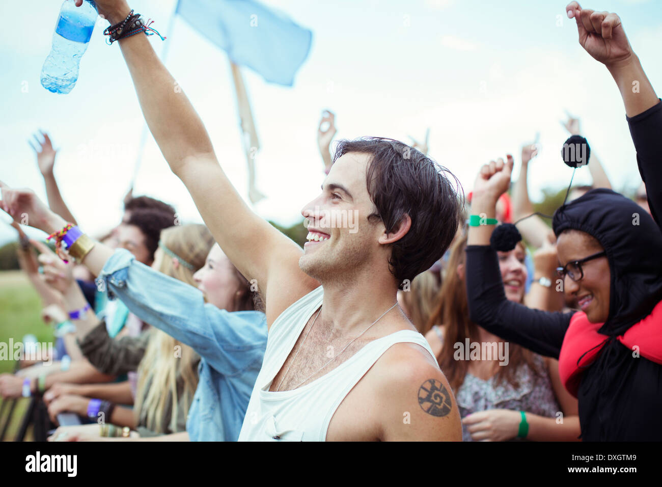 Man with water bottle cheering at music festival Stock Photo