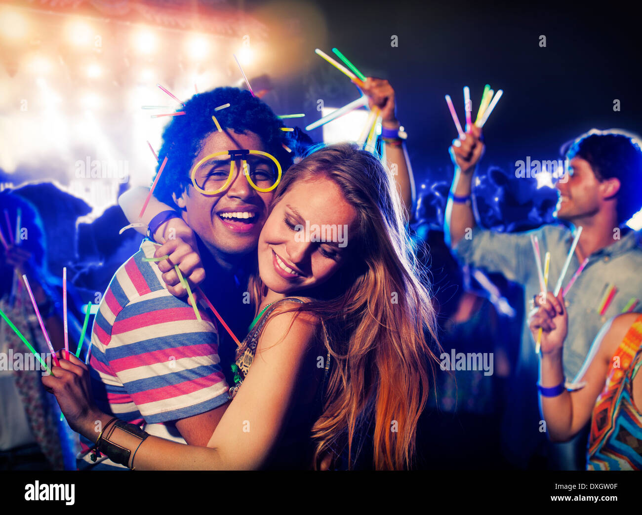 Couple with glow sticks hugging at music festival Stock Photo