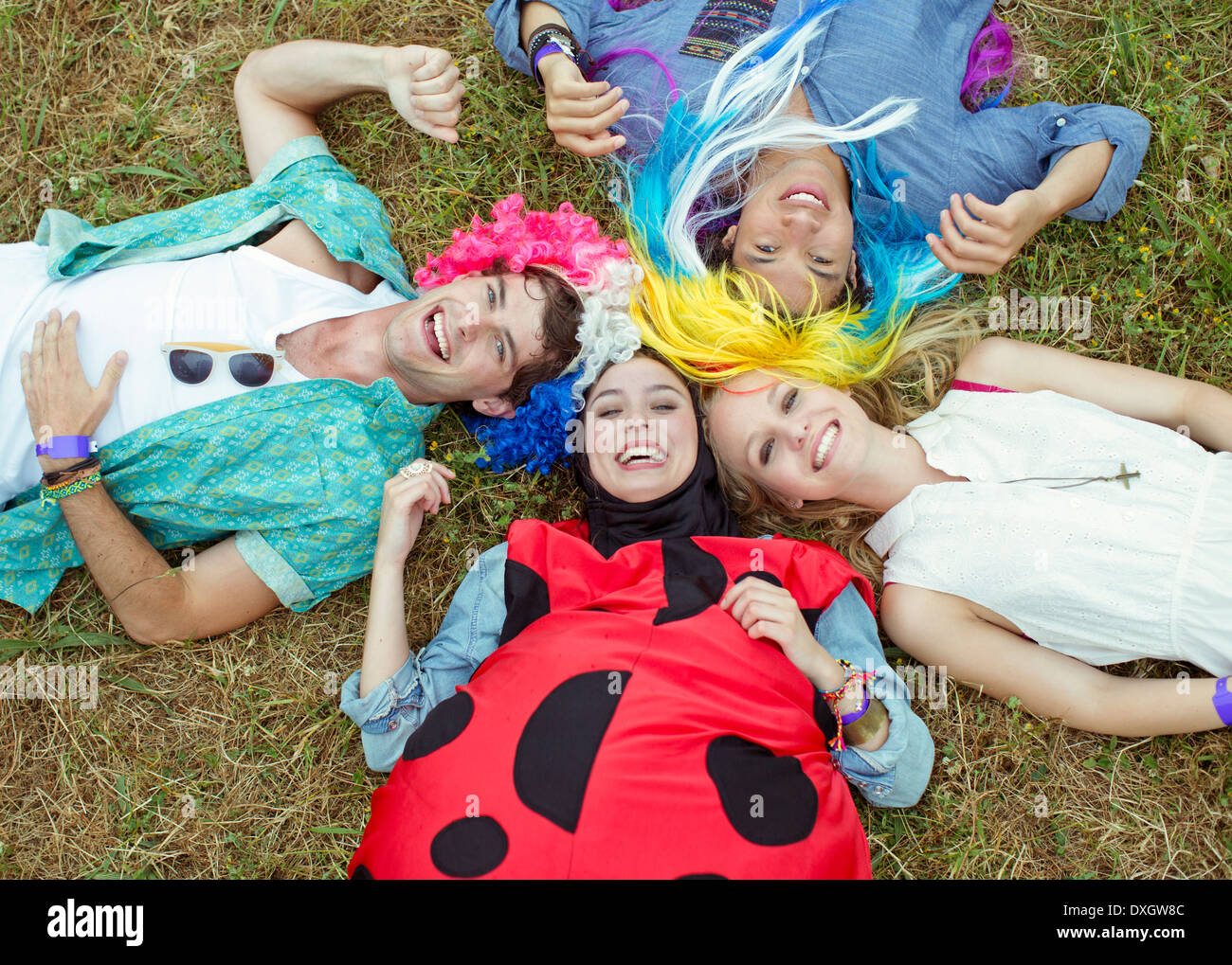 of friends in costumes laying in grass at music festival Stock Photo - Alamy