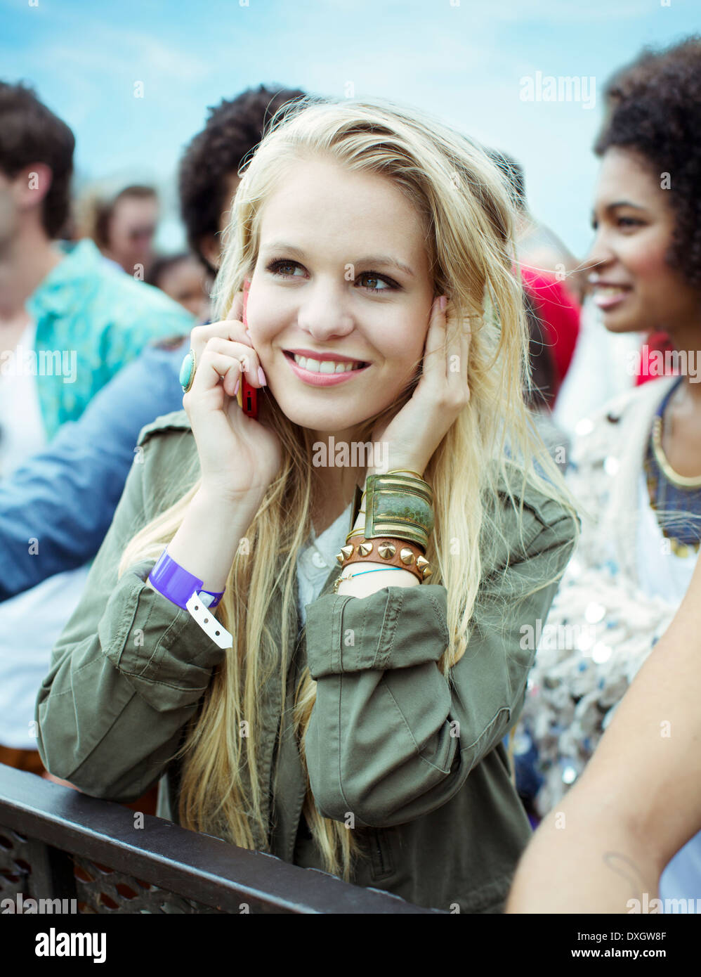 Woman talking on cell phone at music festival Stock Photo