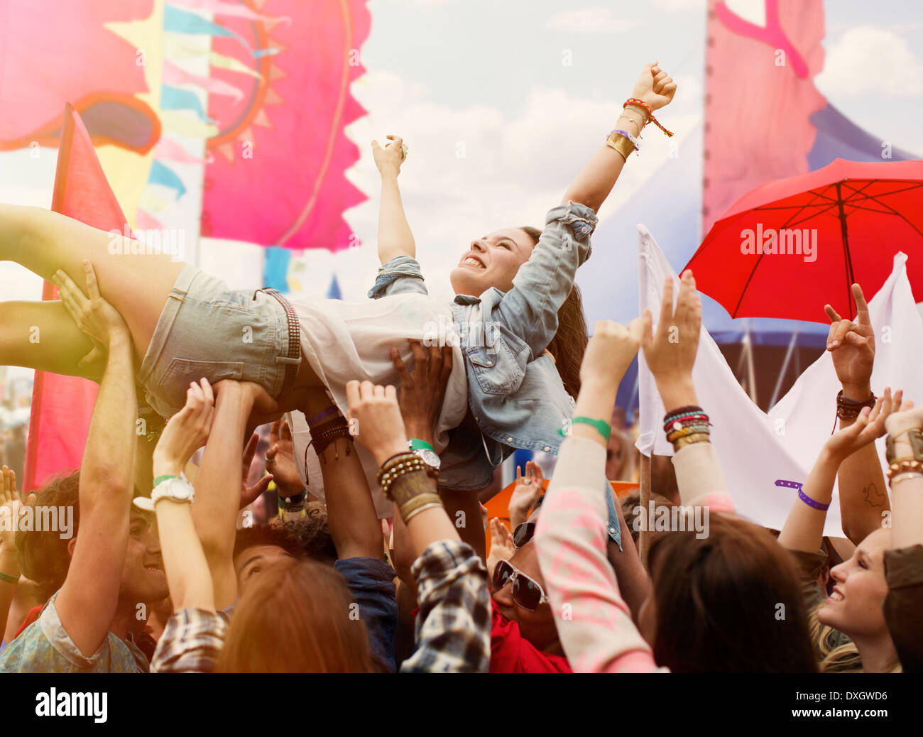Woman crowd surfing at music festival Stock Photo