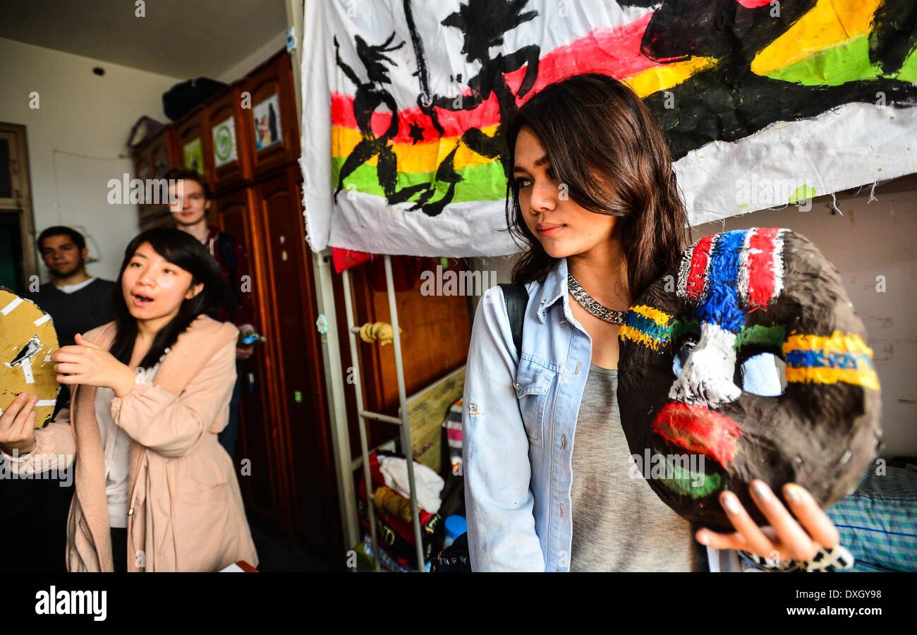 Tianjin, China. 26th Mar, 2014. A student from Indonesia (R) who is the contest judge shows an African mask at an Africa-theme dormitory in Nankai University, Tianjin, north China, March 26, 2014. The College of Chinese Language and Culture of Nankai University launched a dormitory style design contest among students recently. Students use articles at hand to decorate their dormitory with a particular theme showing the culture of different countries and regions. © You Sixing/Xinhua/Alamy Live News Stock Photo