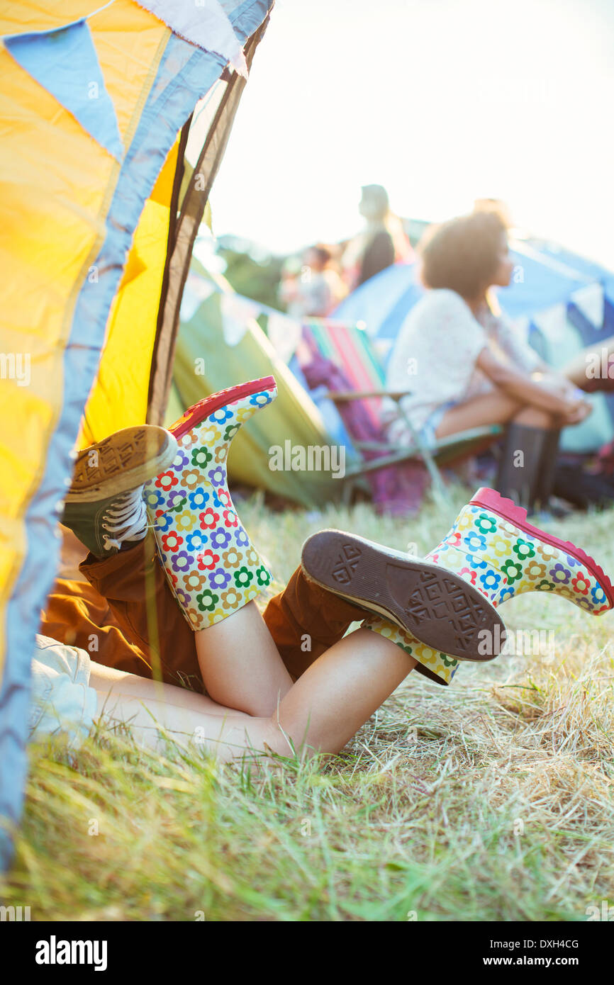 CoupleÍs legs sticking out of tent at music festival Stock Photo