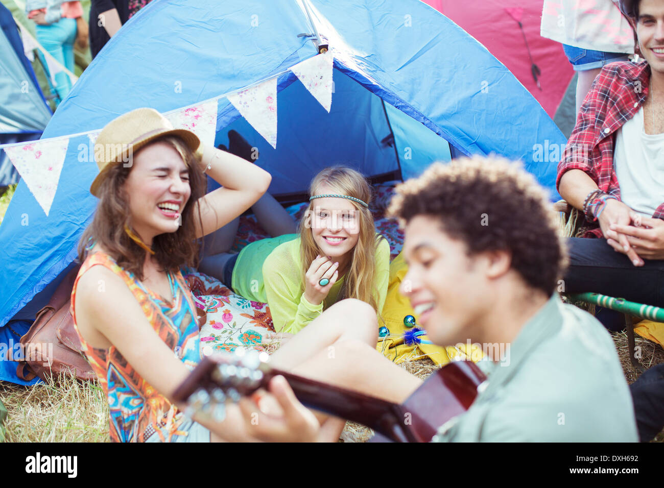 Friends hanging out at tent at music festival Stock Photo