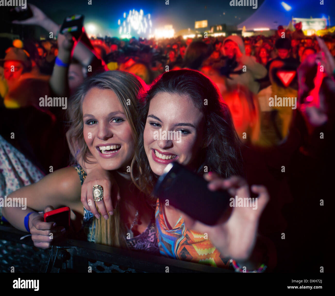 Friends taking self-portrait with camera phone at music festival Stock Photo