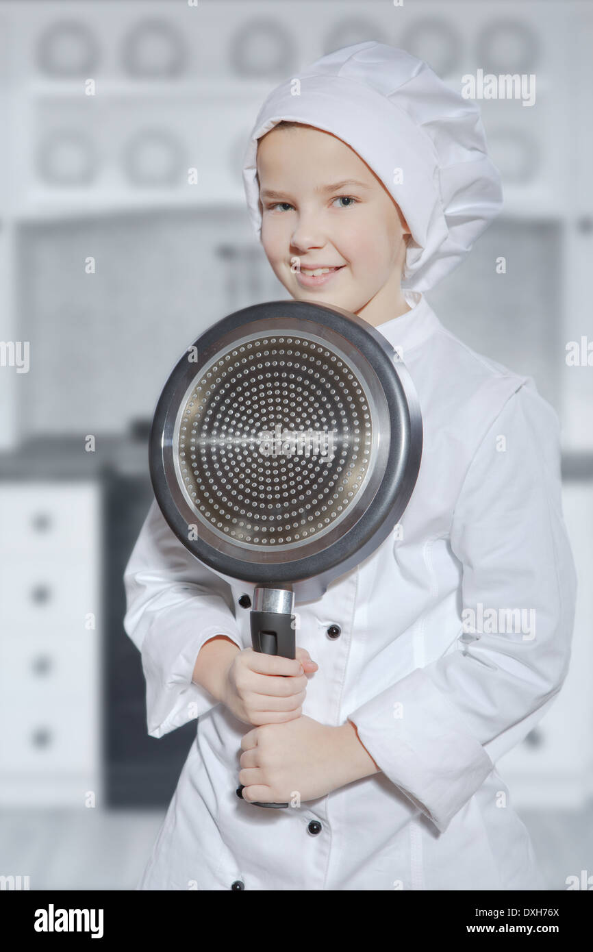 young female teenage cook with a frying pan Stock Photo