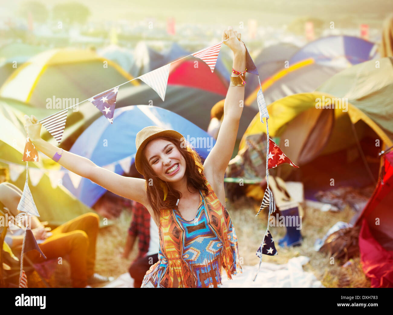 Portrait of enthusiastic woman outside tents at music festival Stock Photo