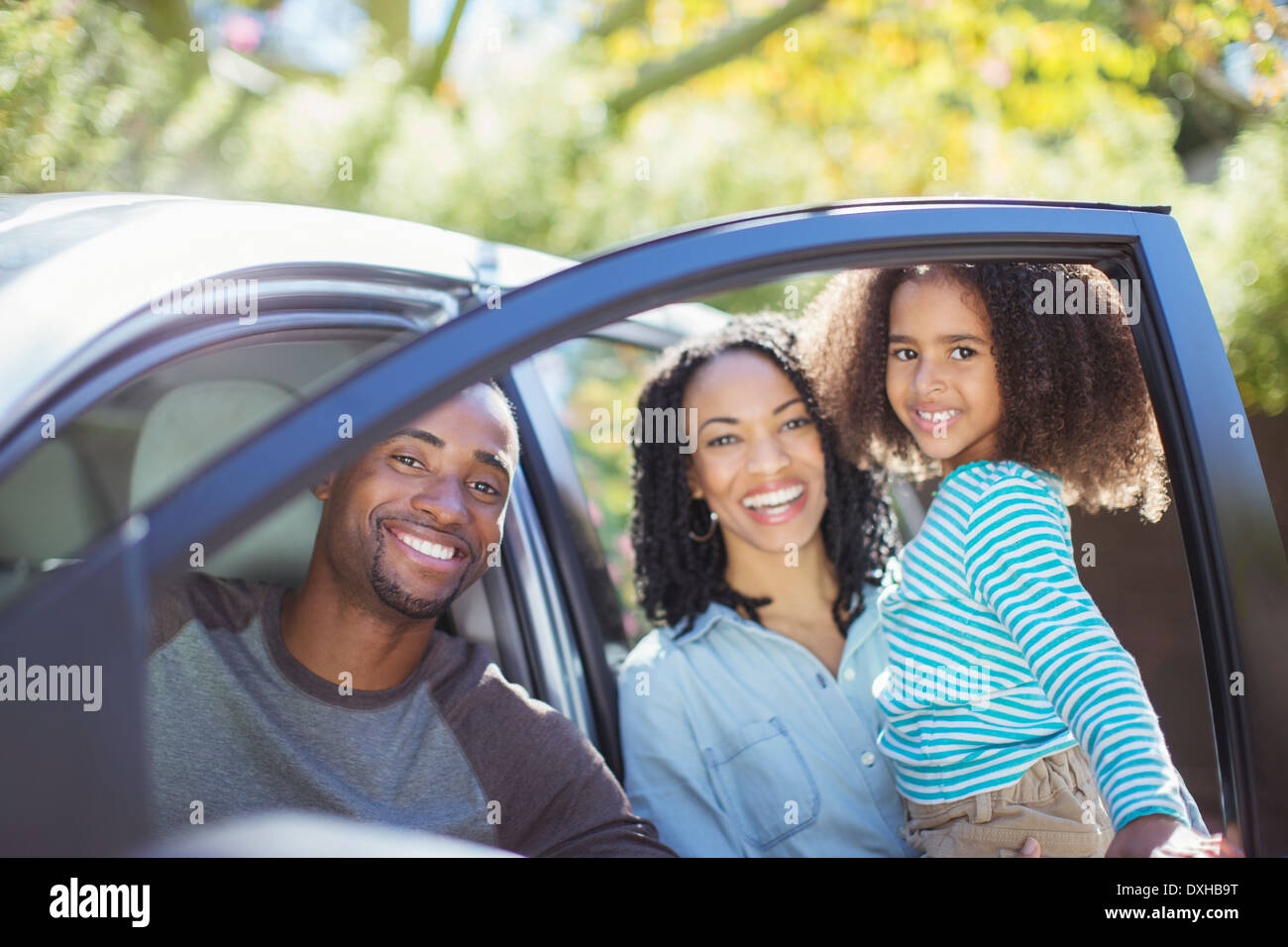 Portrait of happy family inside and outside of car Stock Photo