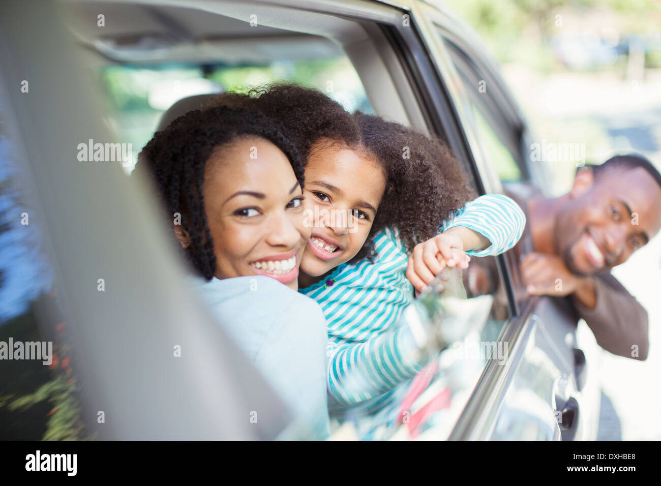 Portrait of happy family leaning out car windows Stock Photo