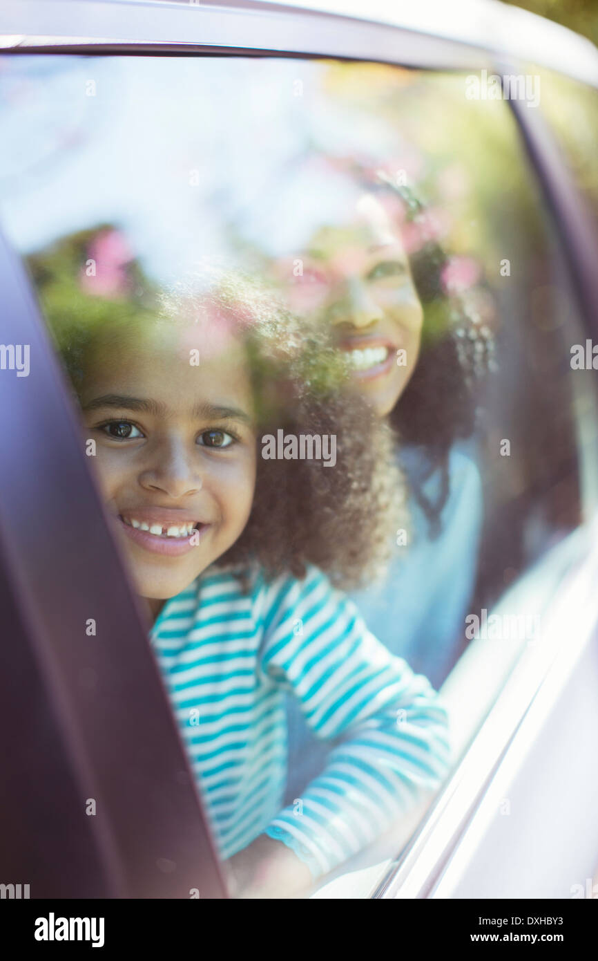 Portrait of smiling car looking out car window Stock Photo