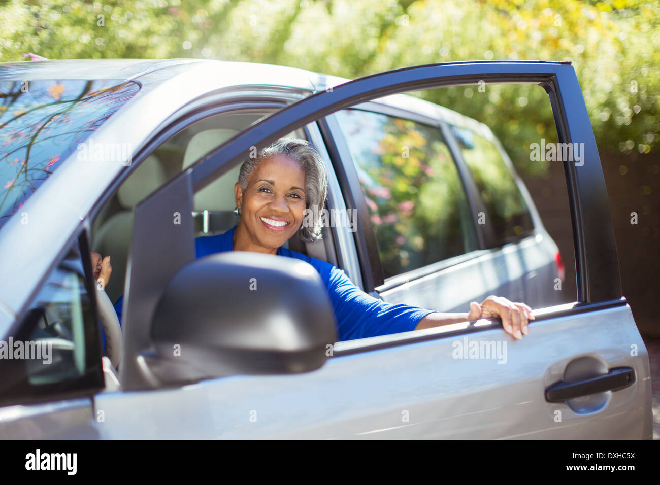Portrait of confident senior woman getting out of car Stock Photo