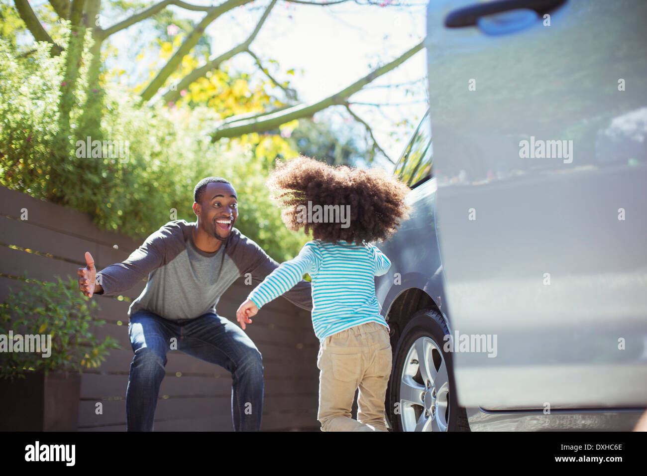 Enthusiastic father greeting daughter outside car Stock Photo