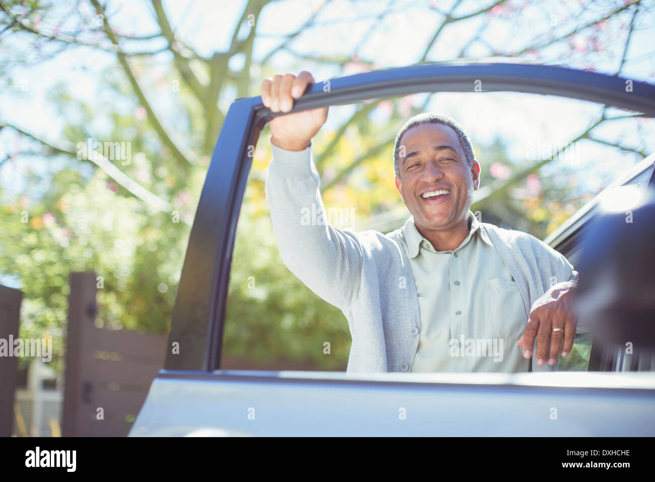 Portrait of happy senior man leaning on car door Stock Photo