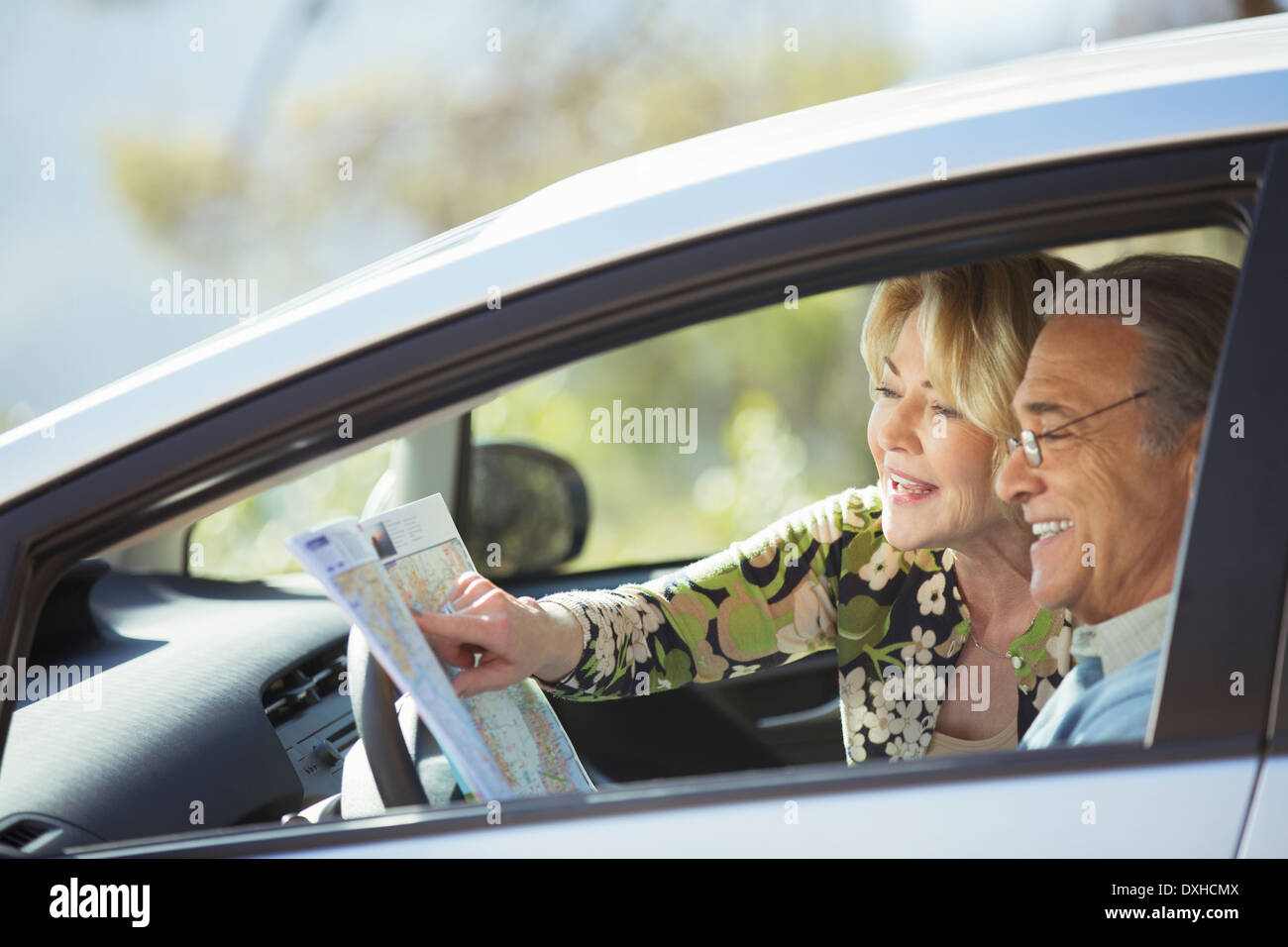 Senior couple looking at map inside car Stock Photo