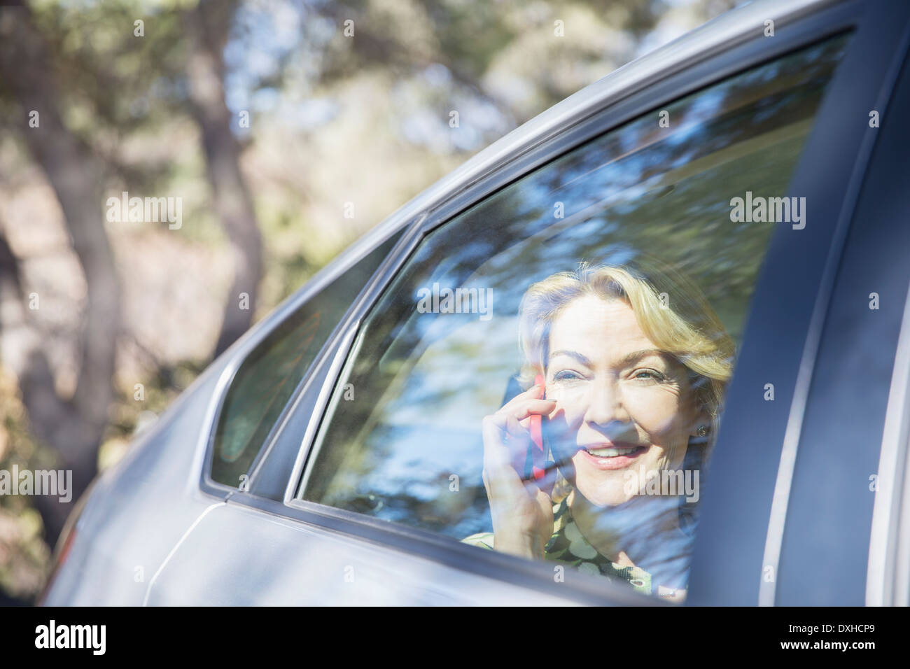 Senior woman talking on cell phone in car Stock Photo