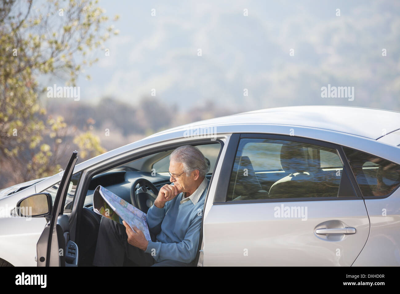 Senior man in car looking at map Stock Photo