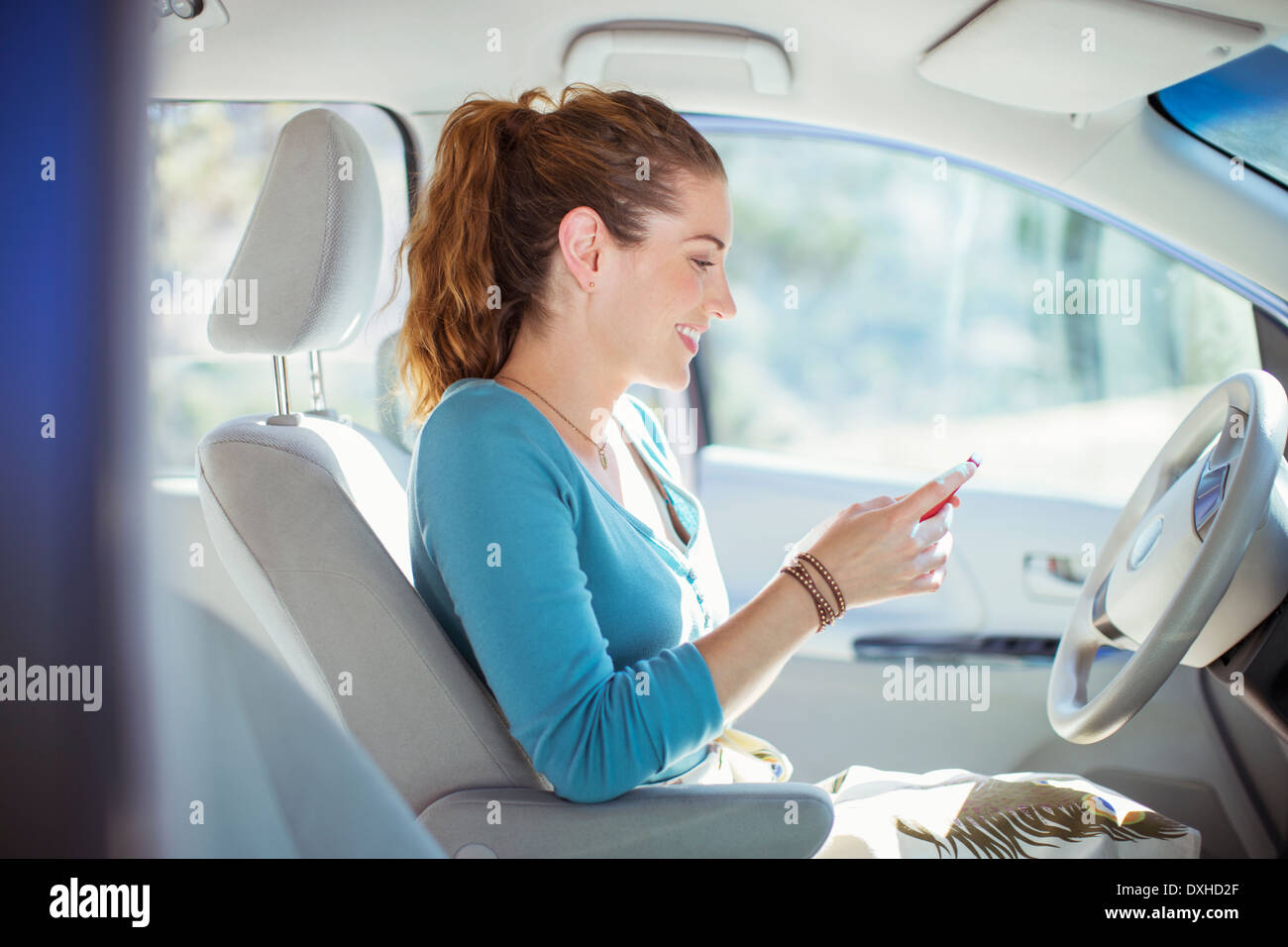 Woman texting with cell phone inside car Stock Photo