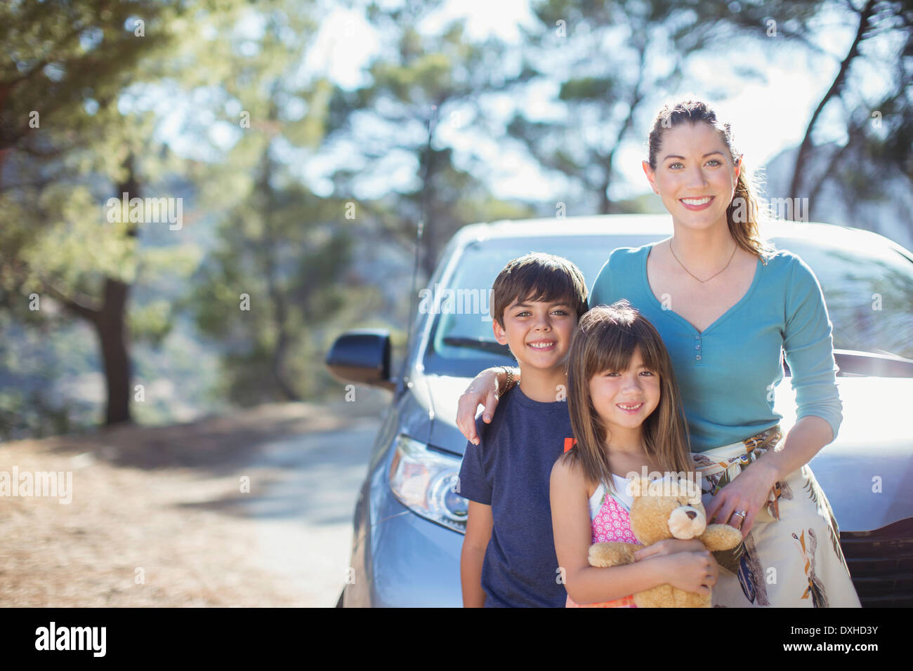 Portrait of happy family leaning on car Stock Photo