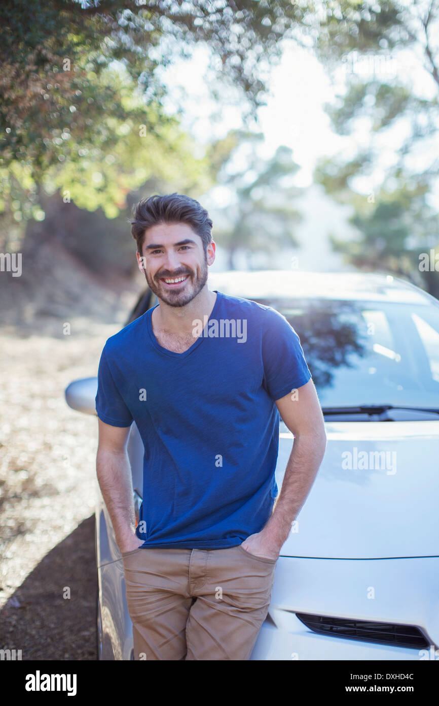 Portrait of smiling man leaning on car Stock Photo