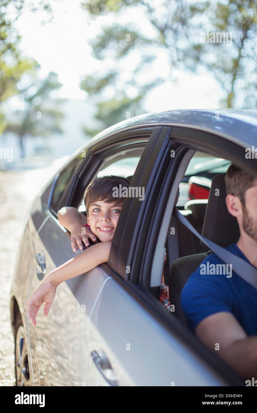 Portrait of smiling boy leaning out car window Stock Photo