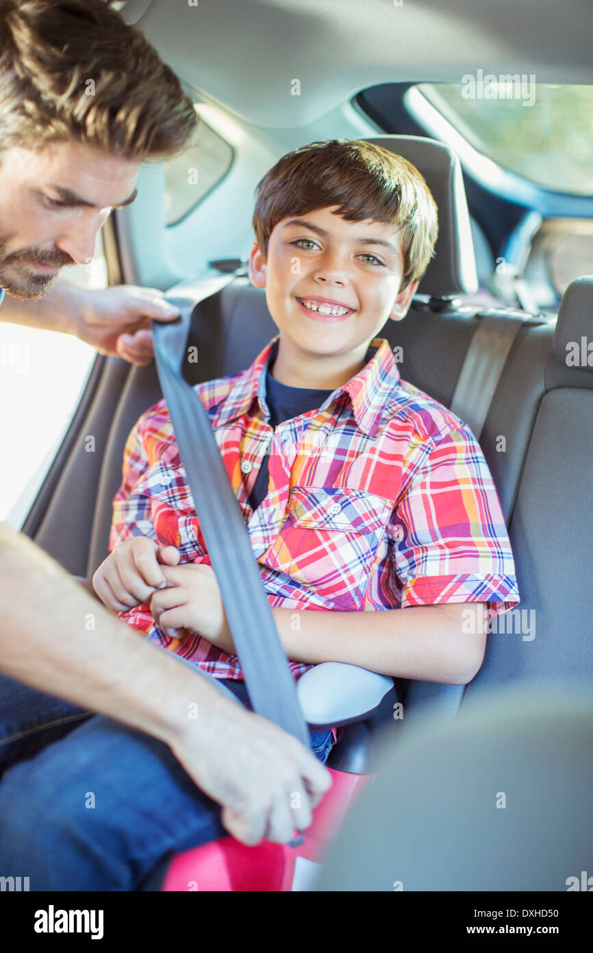 Father fastening seat belt for boy in back seat of car Stock Photo