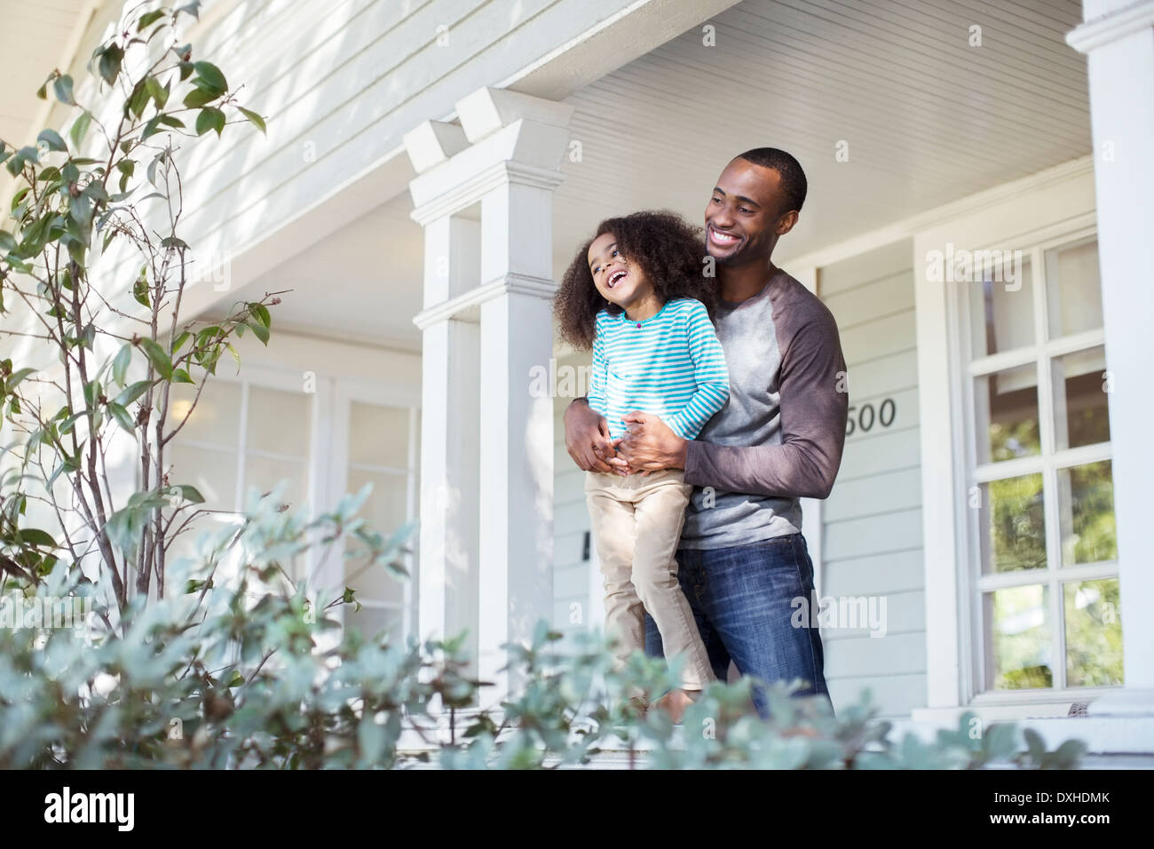 Happy father and daughter on porch Stock Photo