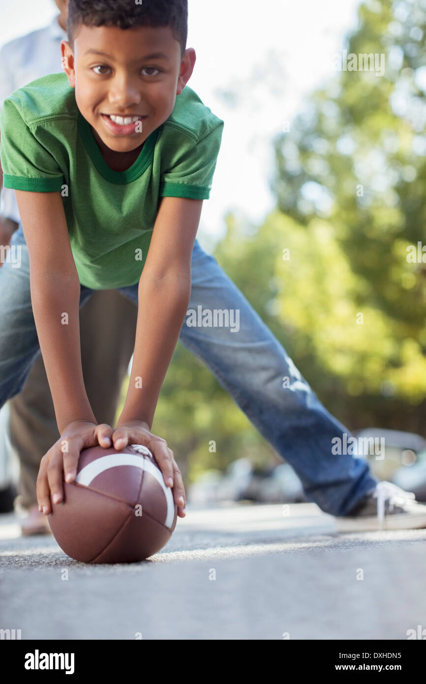 Portrait of smiling boy preparing to snap football Stock Photo