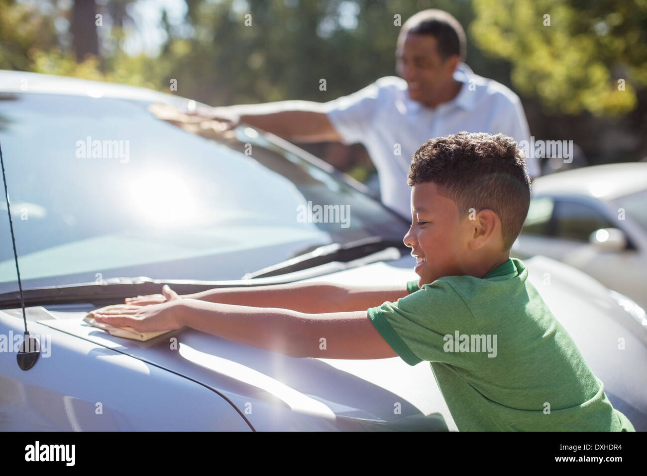 Grandfather and grandson wiping car Stock Photo