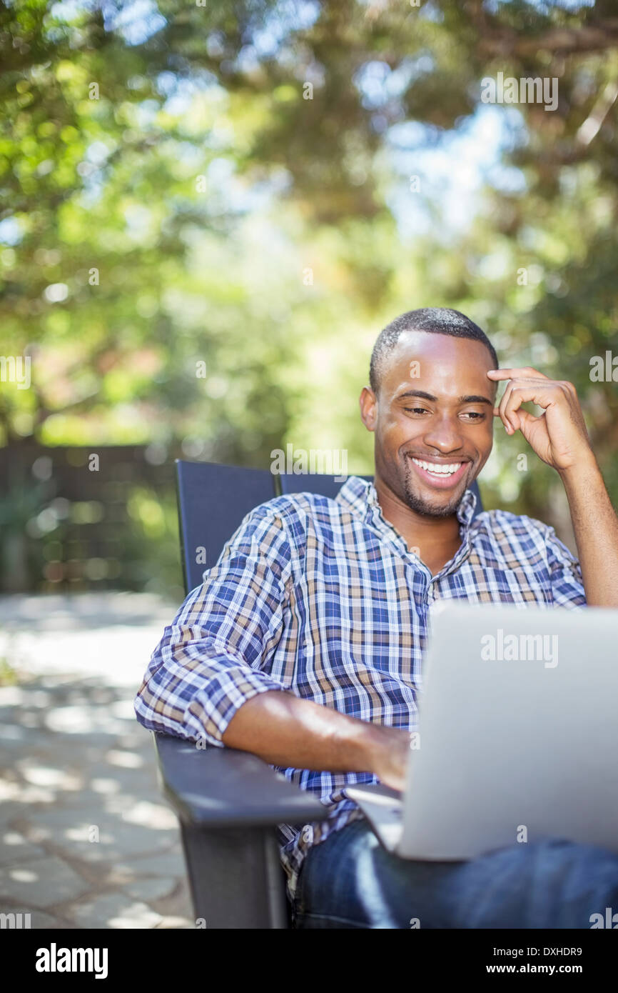 Happy man using laptop outdoors Stock Photo