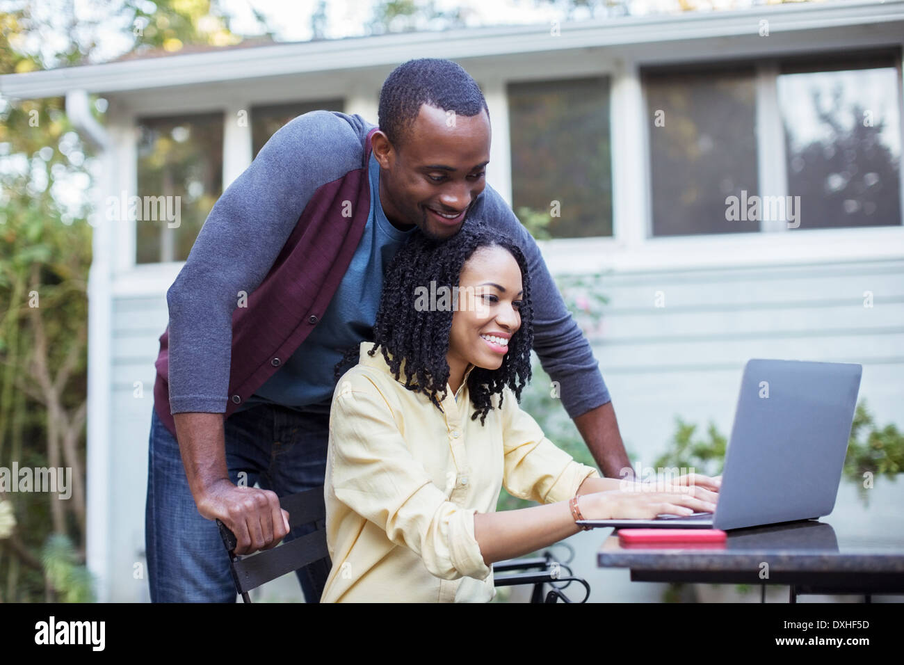 Couple using laptop at patio table Stock Photo