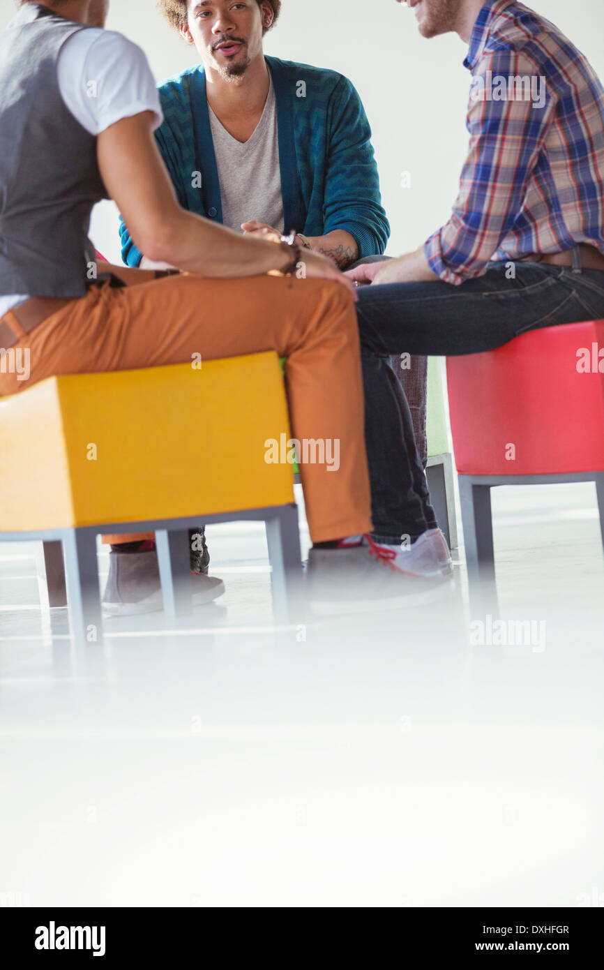 Creative business people meeting in circle on stools Stock Photo
