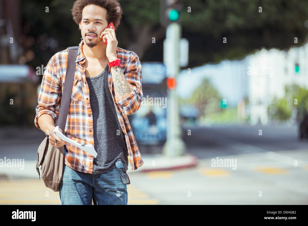 Man talking on cell phone in urban crosswalk Stock Photo