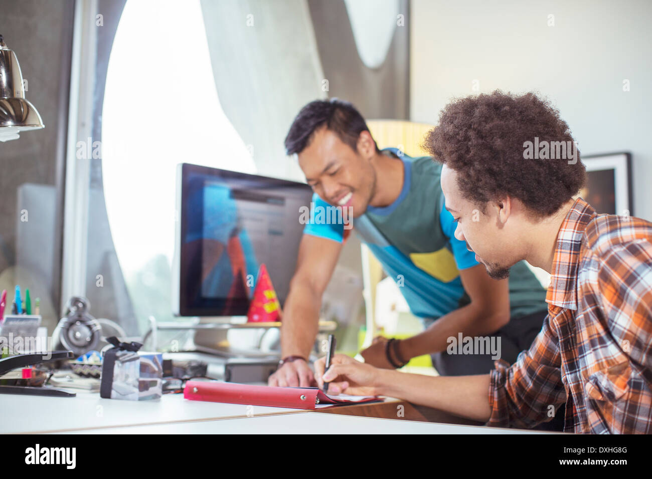 Casual businessmen reviewing paperwork in office Stock Photo