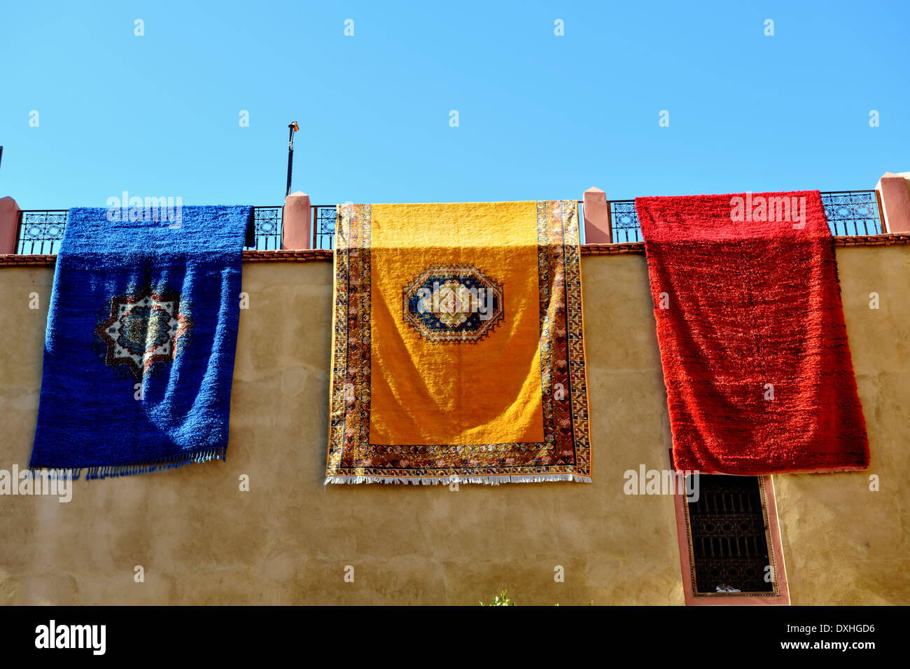 Red, yellow and blue rugs hanging on wall, Marrakech, Morocco Stock Photo